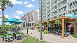 Een hotel binnenplaats met buitenplaatsen, een bord en een gebouw met meerdere balkons.