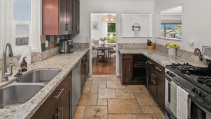 A kitchen with granite countertops, stainless steel appliances, and dark wooden cabinets. - Charming retreat with AC and outdoor oasis, just 3 blocks from Lafayette Hotel (San Diego)