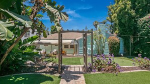 A house with a covered patio, a lawn, and various plants. - Charming retreat with AC and outdoor oasis, just 3 blocks from Lafayette Hotel (San Diego)