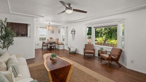A spacious living area with a wooden coffee table, a sofa, and a dining table with chairs. - Charming retreat with AC and outdoor oasis, just 3 blocks from Lafayette Hotel (San Diego)