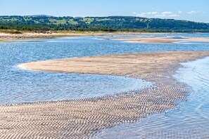 A riverbank with a sandy beach and a forested hill in the background. - Skummeslöv Beach Home B, Skummeslövstrand, Sweden (Skummeslövstrand)
