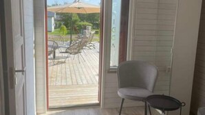 A room with a sliding glass door leading to an outdoor patio with a table and chairs. - Skummeslöv Beach Home B, Skummeslövstrand, Sweden (Skummeslövstrand)