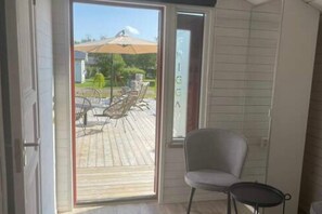A room with a sliding glass door leading to an outdoor patio with a table and chairs. - Skummeslöv Beach Home B, Skummeslövstrand, Sweden (Skummeslövstrand)