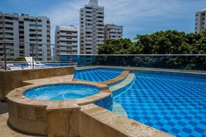 Ein Dachpool mit Schachbrettmuster, umgeben von Hochhäusern und Grünflächen.