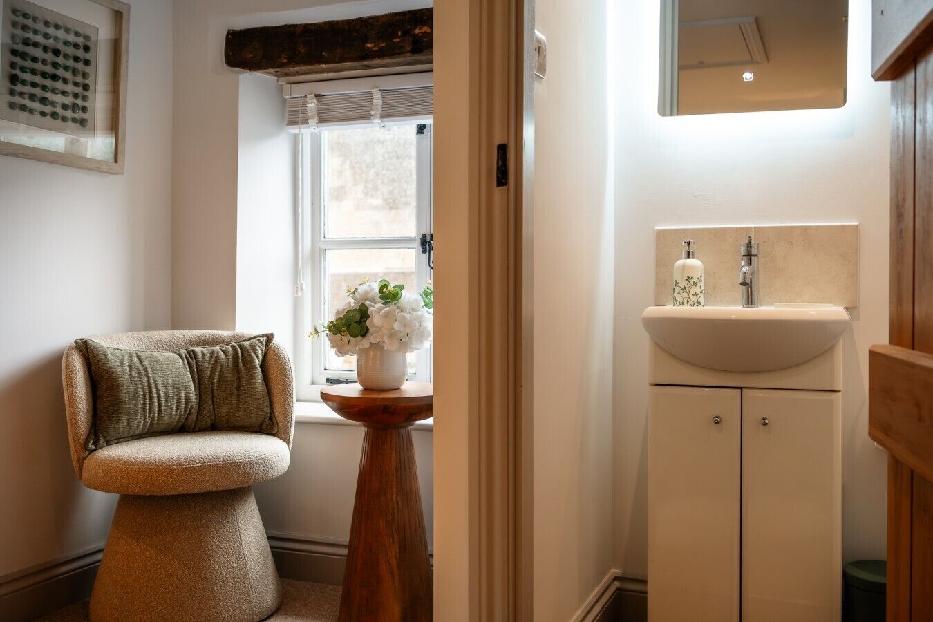 A bathroom with a sink, mirror, and window.