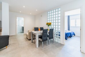A modern dining area with a marble table, black chairs, and a vase with sunflowers. - Cabrera Apartment by Mallorca Infinity (Peguera)