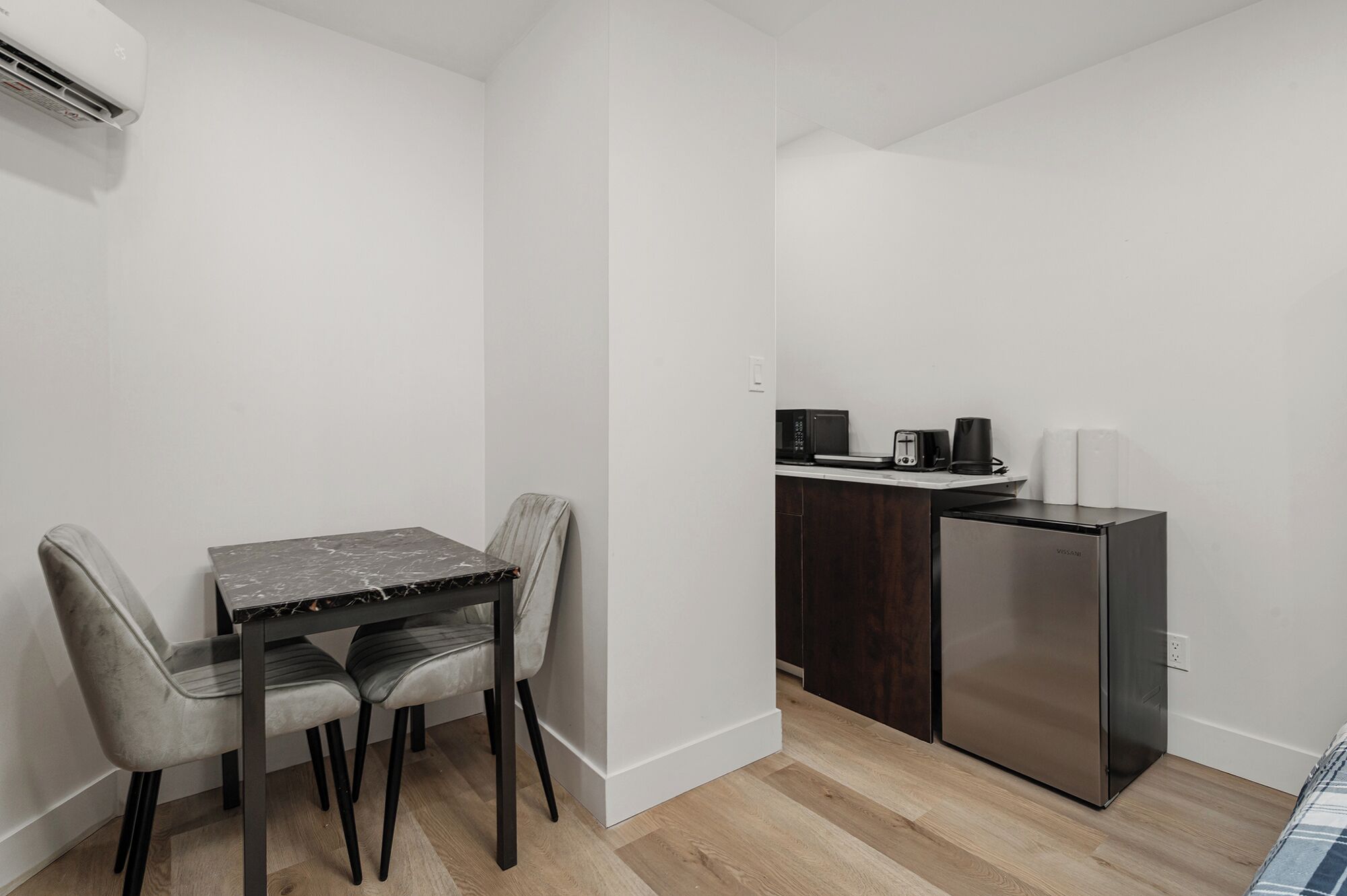 A compact kitchen with a refrigerator, microwave, and toaster on a countertop.