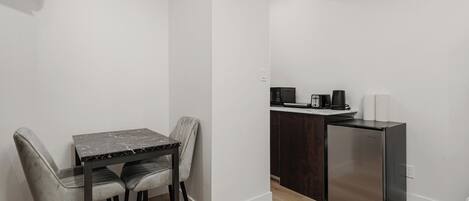 A compact kitchen with a refrigerator, microwave, and toaster on a countertop.