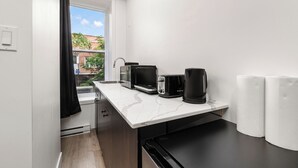 A compact kitchenette with a sink, a microwave, a toaster, and a coffee maker.