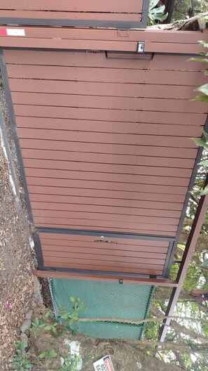 A brown metal gate with a chain-link fence behind it. - A cozy place to enjoy Monteverde and its magic (Santa Elena)