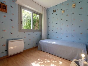 A bedroom with a single bed, a window, a radiator, and floral wallpaper. - Les Portes de la Mer by Interhome (Villers sur mer)