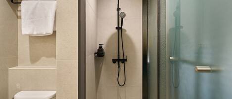 A bathroom with a shower, toilet, and towel rack.