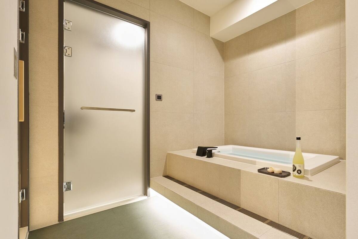 Un baño moderno con bañera, perchero y una botella de champú.