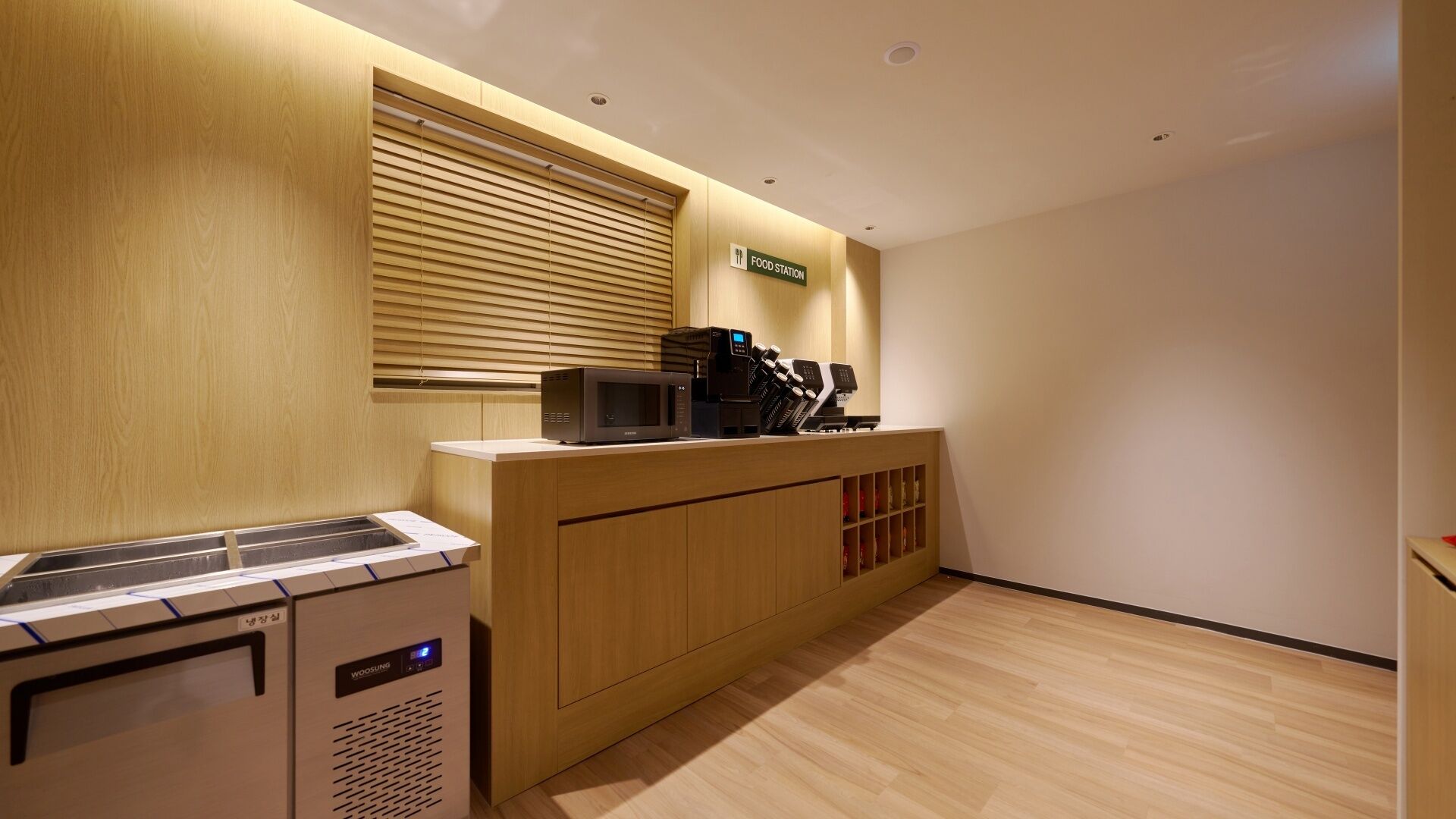 Una kitchenette equipada con microondas, cafetera y un refrigerador pequeño.