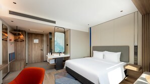 A modern hotel room with a large bed, a desk, a chair, and a bathroom. - Holiday Inn Express Luoyang Longmen (Luoyang)