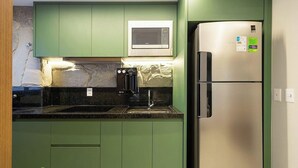 A kitchen with green cabinets, a stainless steel refrigerator, a microwave, and a water dispenser. - Apto in Condo w/ Pool in Setor Marista Liu2306 (Goiânia)
