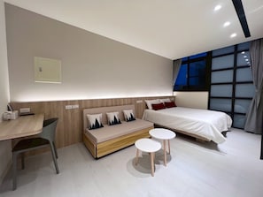 A modern hotel room with a bed, bedside tables, a sofa, a desk, and a chair. - Phoenix Landing (Tainan)