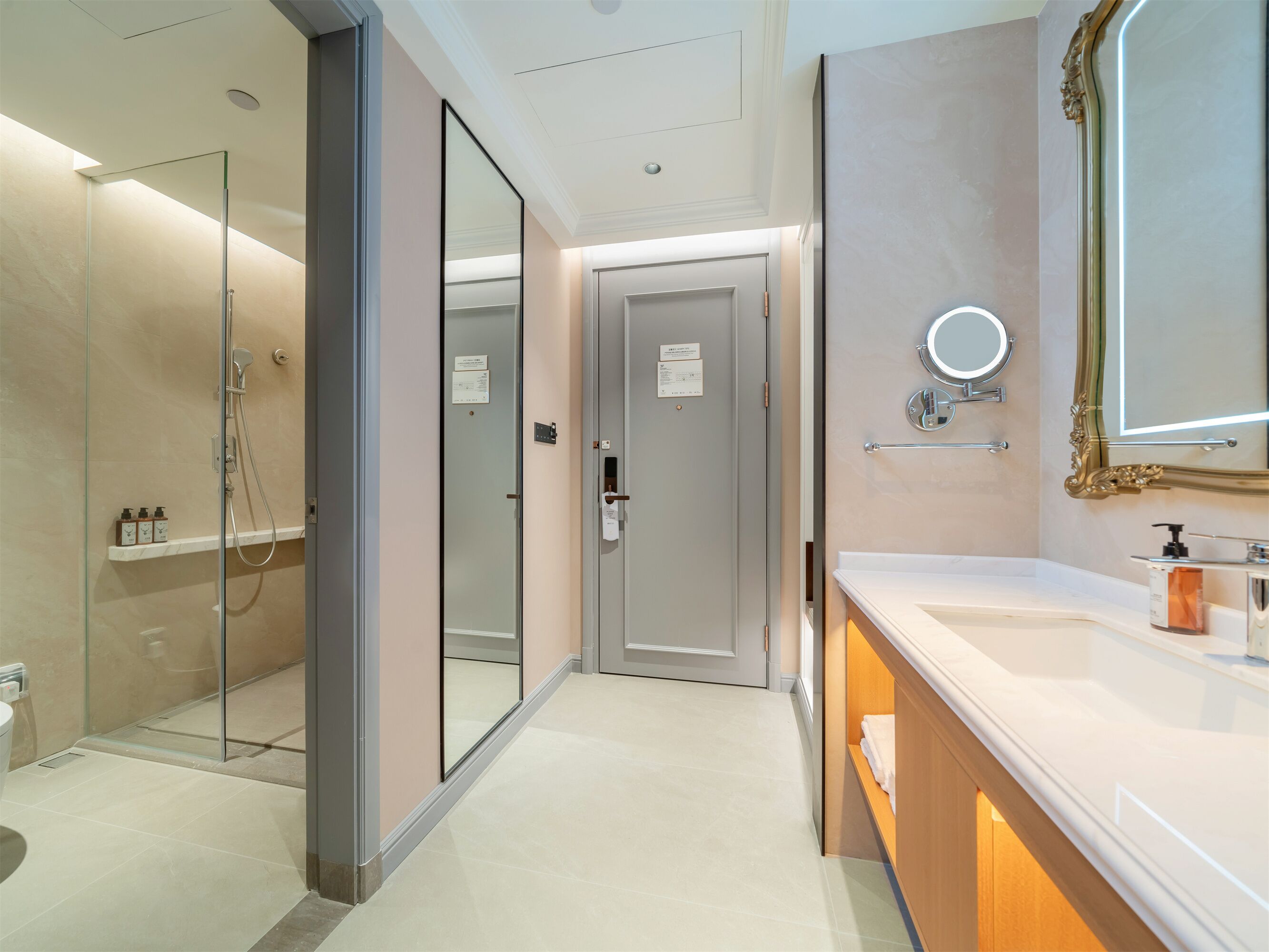 Un baño moderno con cabina de ducha de vidrio, tocador con espejo y un inodoro.