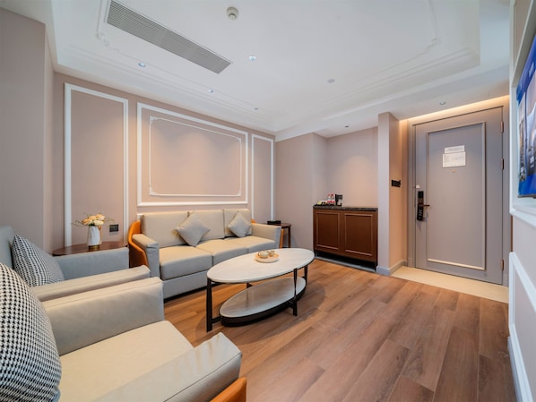 A modern living room with a sofa, coffee table, and a cabinet. - Vienna International Hotel Guangzhou Baiyun International Airport Branch - Free Shuttle Bus to Guangzhou Baiyun International Airport & Free Deliver Service to Canton Fair Complex During Canton Fair Period (Guangzhou)