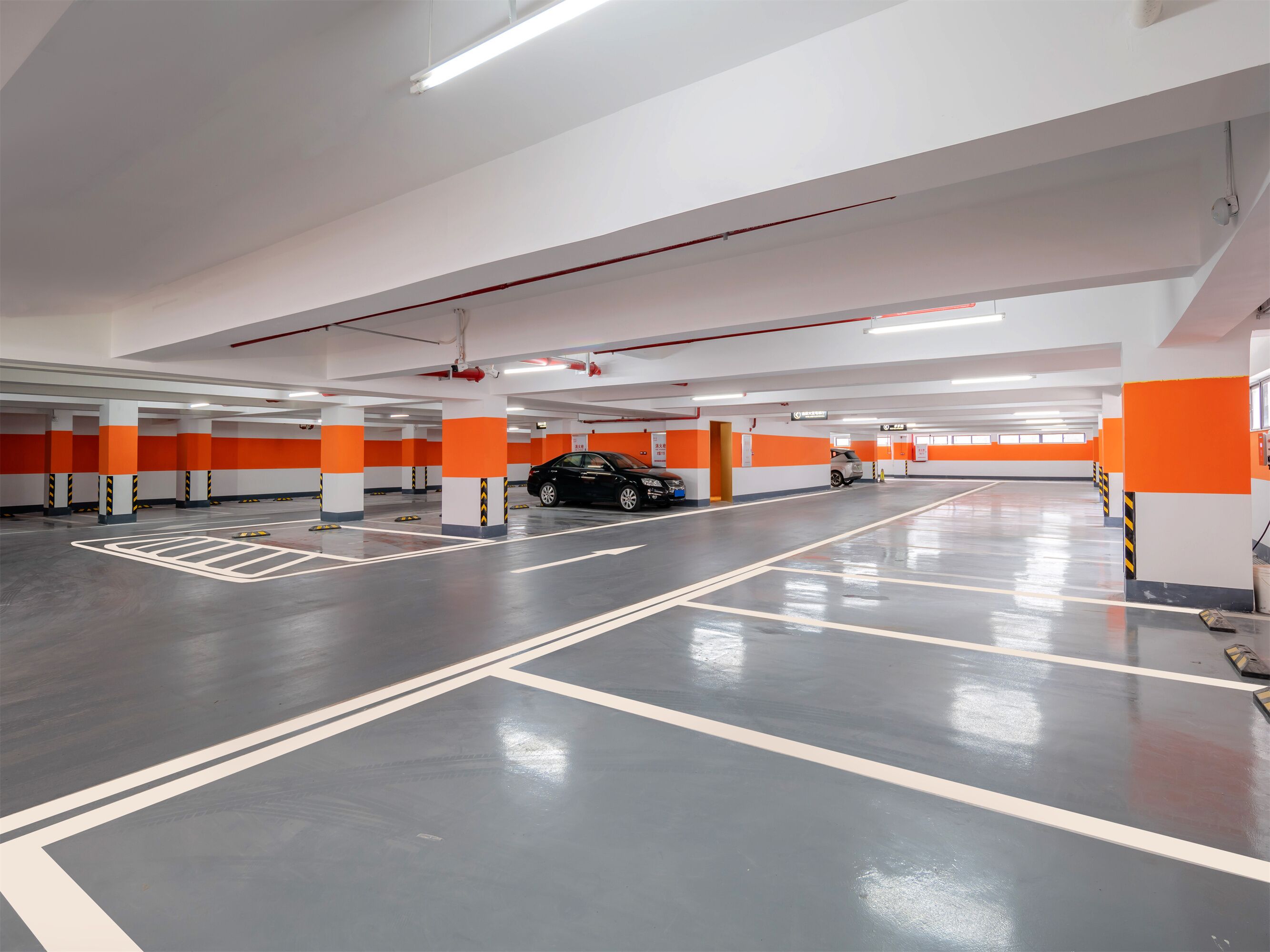 Un aparcamiento de varios niveles con marcas de carril claras y barreras de seguridad anaranjadas.