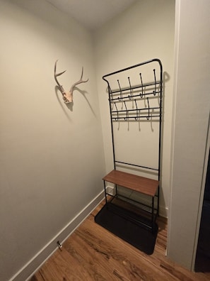 Ein Eckzimmer mit einer Wandhalterung, einem Holzregal und einer Dekoration mit einem Hirschschädel.