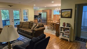 A living room with a sofa, a lamp, a bookshelf, and a dining area with a table and chairs. - Two bedroom  in United States of America, Glenville (Glenville)