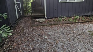 A small, dark-colored building with a front door, a window, and a porch. - Two bedroom  in United States of America, Glenville (Glenville)