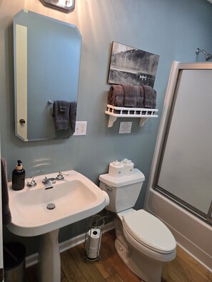 A bathroom with a sink, toilet, and shower. There are towels on a rack and a sign on the wall. - Two bedroom  in United States of America, Glenville (Glenville)