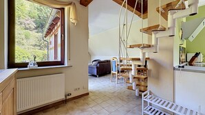 Eine Küche mit Fenster, Heizkörper, Treppe und Essbereich.