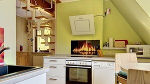 Eine Küche mit Herd, Backofen, Mikrowelle und einem wandmontierten Kamin.