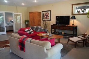 A living room with a sofa, a coffee table, a TV, and a cabinet.