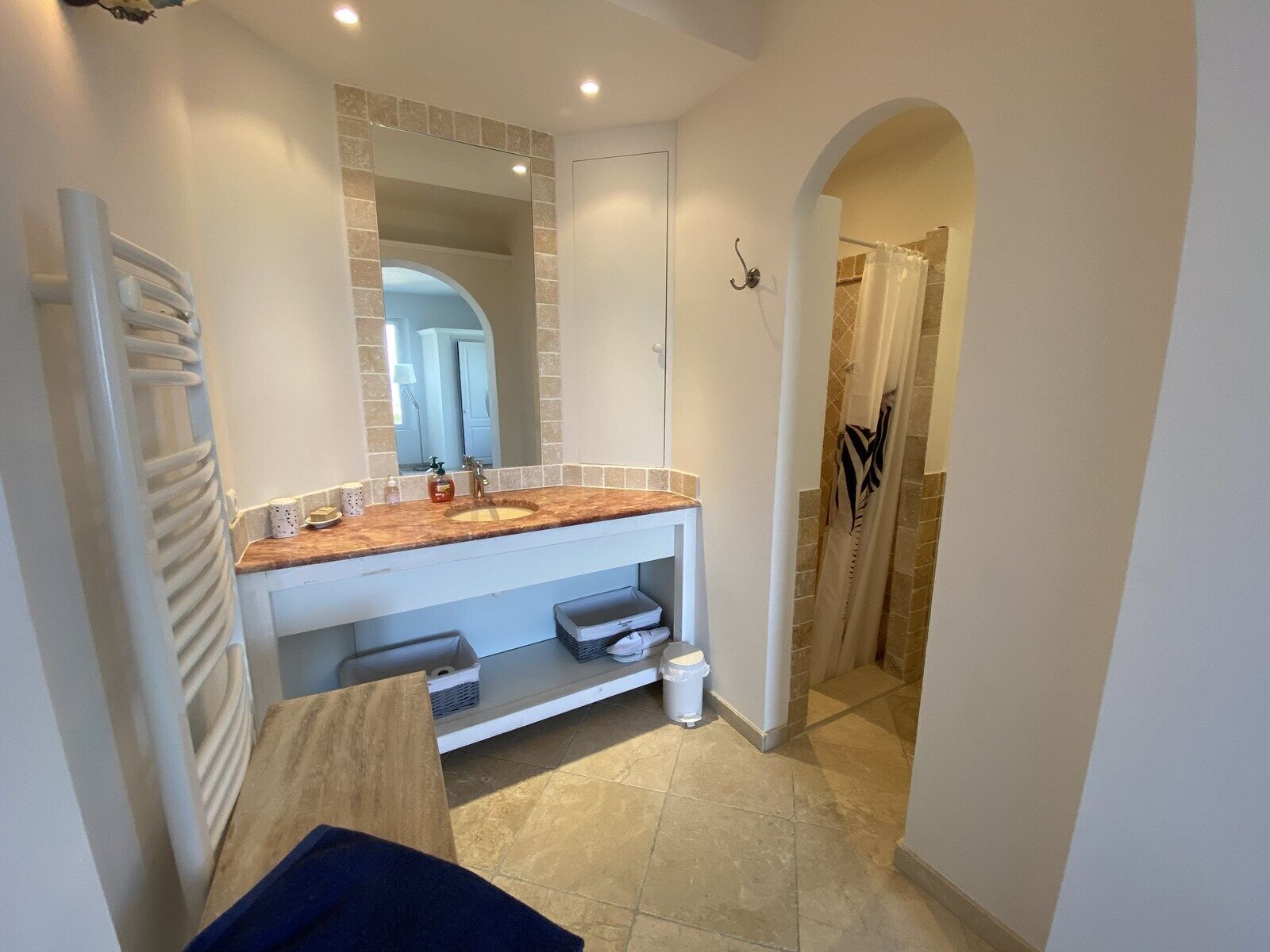 A modern bathroom with a sink, mirror, and shower.