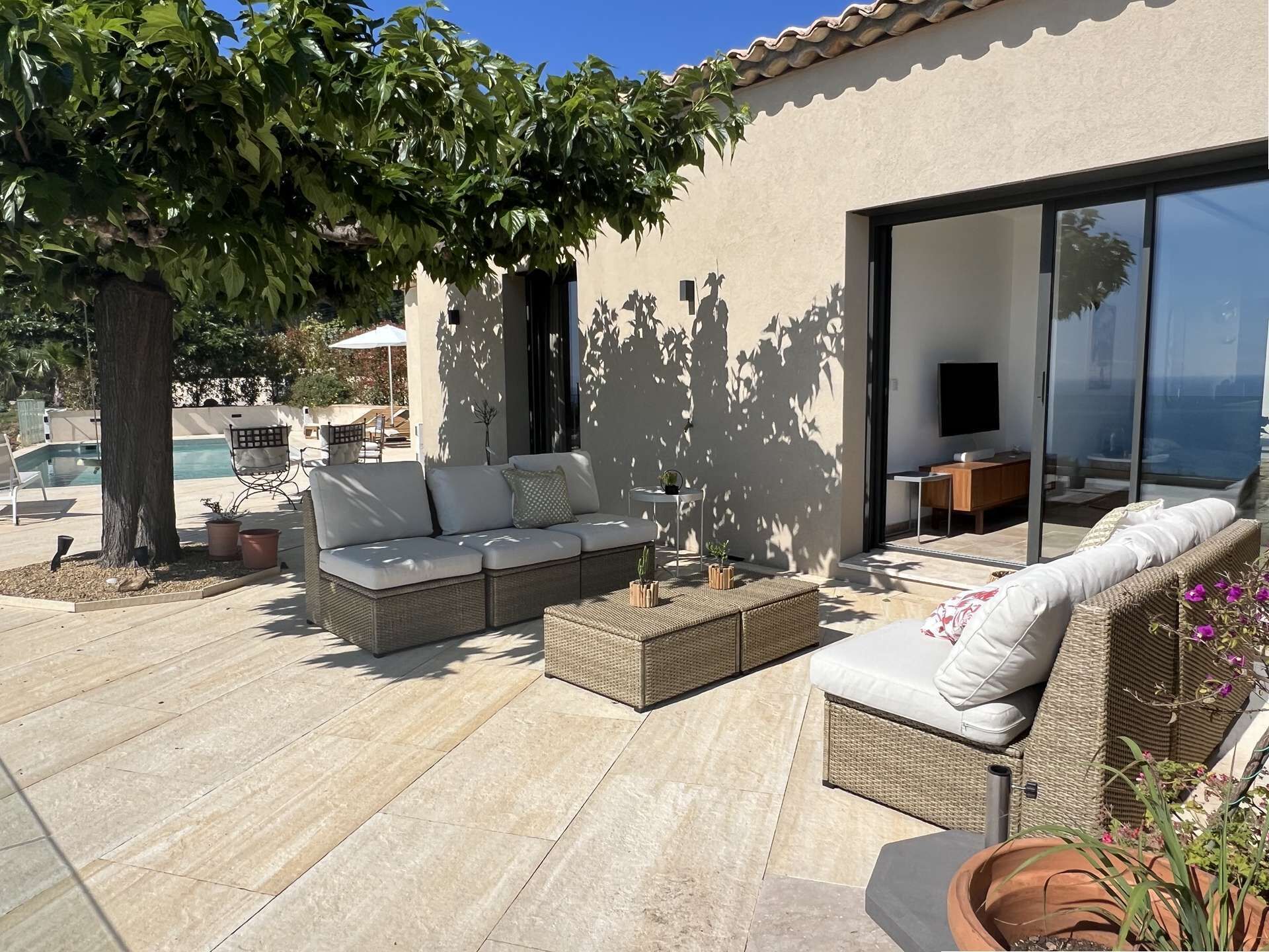 Eine Terrasse mit einer Sitzecke, einem Couchtisch und einem Esstisch.