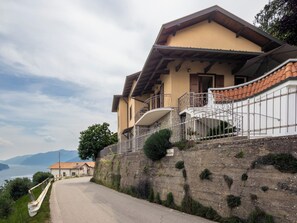 Ein Haus mit Steinwand, Balkon und Bergblick.
