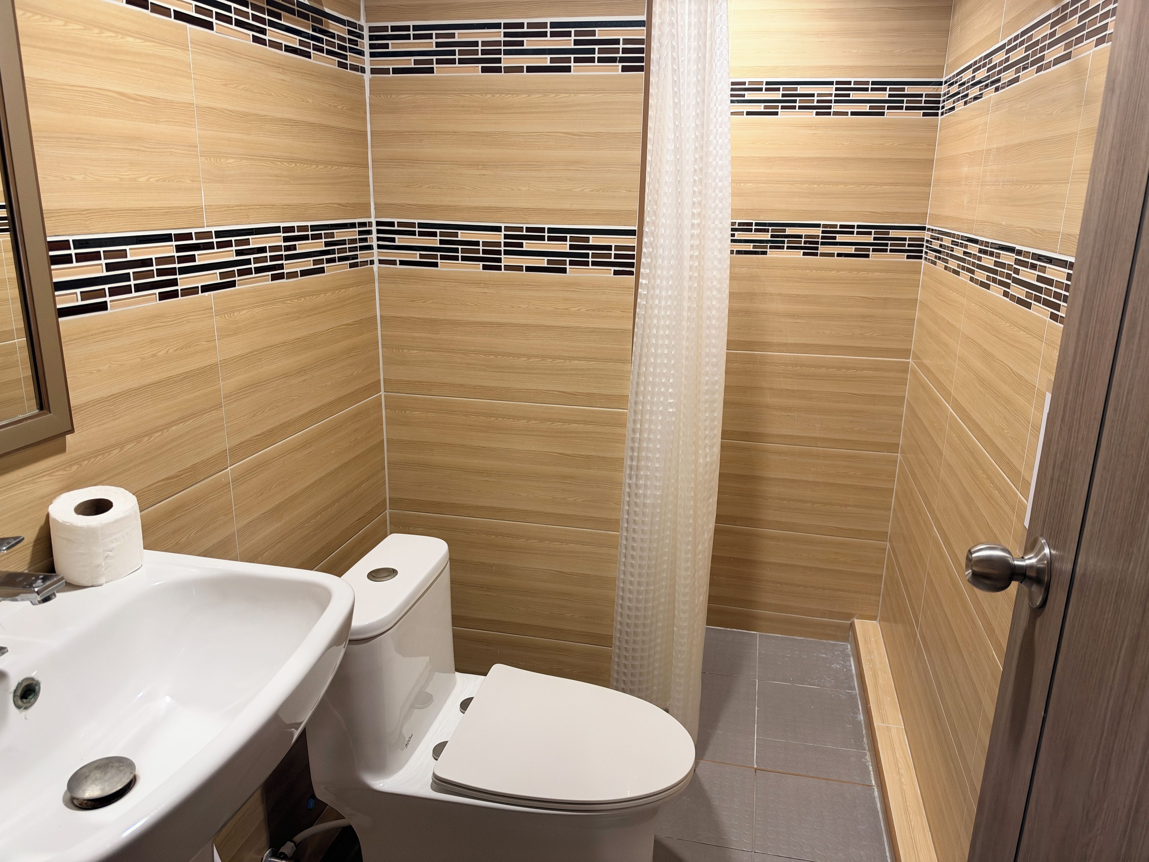 A bathroom with a sink, toilet, and shower curtain.