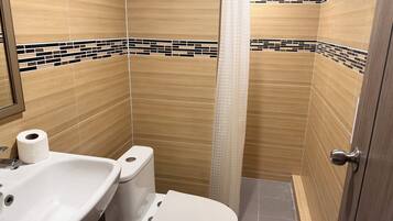 A bathroom with a sink, toilet, and shower curtain.