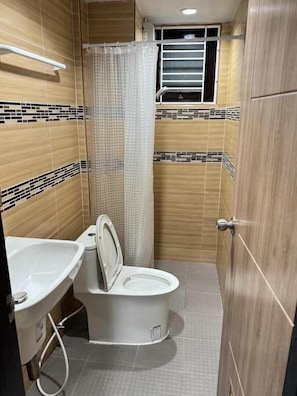 A bathroom with a toilet, sink, and shower curtain. - Miley Phi Phi Guesthouse (Ko Phi Phi)