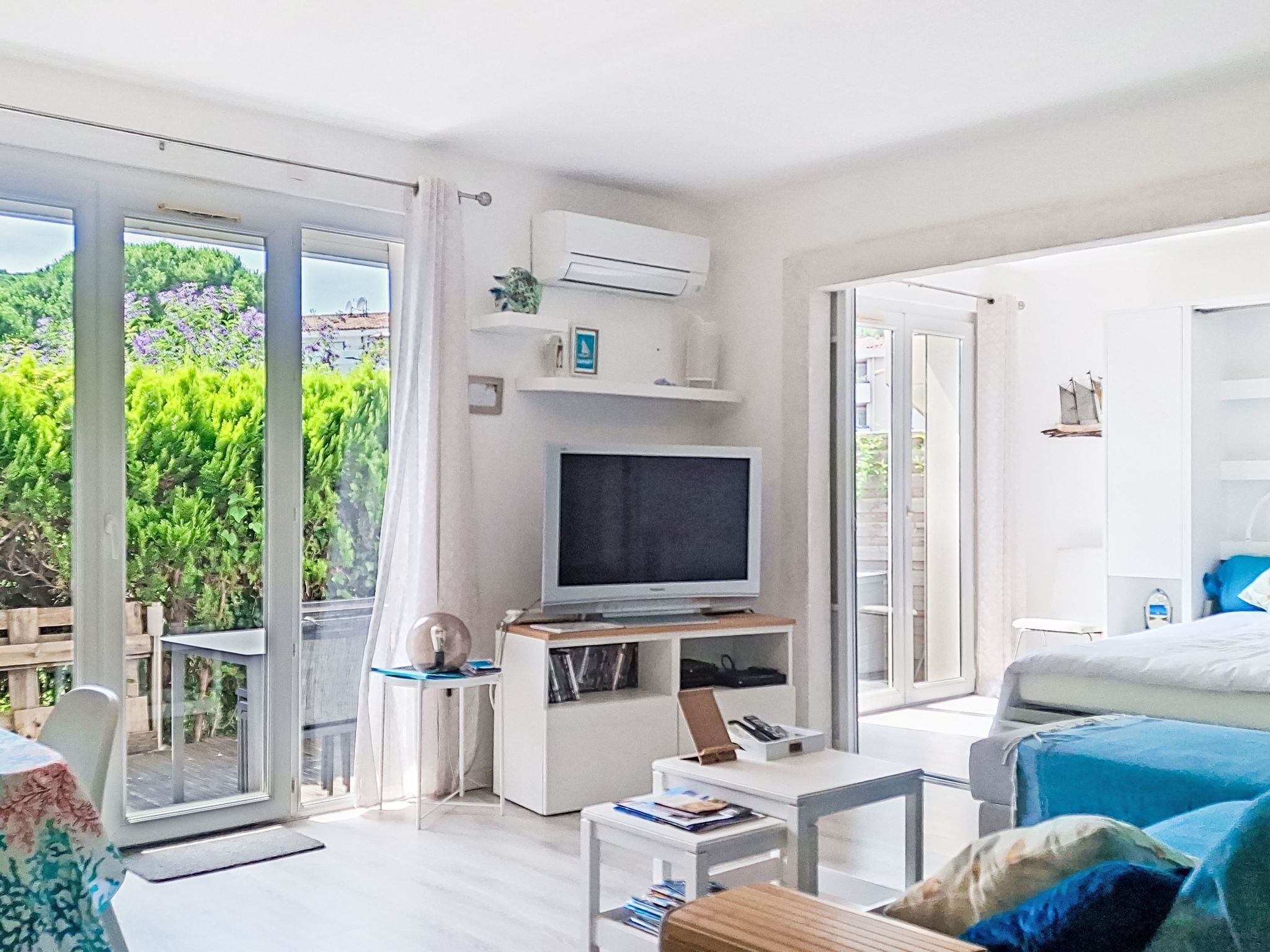 Una habitación moderna con televisión, escritorio, silla y cama.