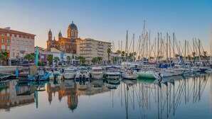 A marina with boats docked, a large building with domes, and a clear sky. - SAINT-RAPHAËL CITY CENTER – BEACH WITHIN WALKING DISTANCE – COMFORTABLE 1-BEDROOM APARTMENT (ST RAPHAEL)