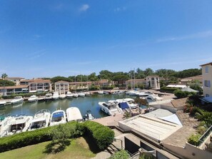 A marina with boats docked, surrounded by residential buildings with Mediterranean architecture. - Charmant Appt Vue Marina Exceptionnelle  et  Piscine Collective à  Port-Cogolin (COGOLIN)