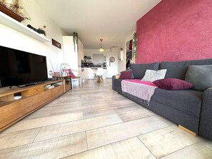 Ein Wohnzimmer mit Fernseher, Sofa und einer Holzunterhaltungsecke.