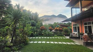 A modern building with a garden and a view of mountains. - Khao Sok Country Resort (Phanom)