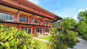 A two-story building with a balcony, large windows, and a well-maintained garden. - Khao Sok Country Resort (Phanom)