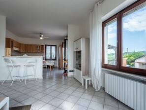 Eine moderne Küche mit Essbereich, großen Fenstern und Blick ins Grüne.
