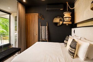 A modern bedroom with a large bed, a wooden wardrobe, a mirror, and a hanging light fixture. - 
Luxury Tulum Loft With Rooftop Pool (Tulum)