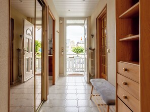 A hallway with a bench, wooden cabinets, and a view to the outside. - Villerville by Interhome (Villerville)