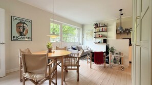 A spacious living area with a dining table, chairs, a sofa, and a bookshelf. - City Apartment in Stengade with 1 bedrooms sleeps 2 (Stengade)