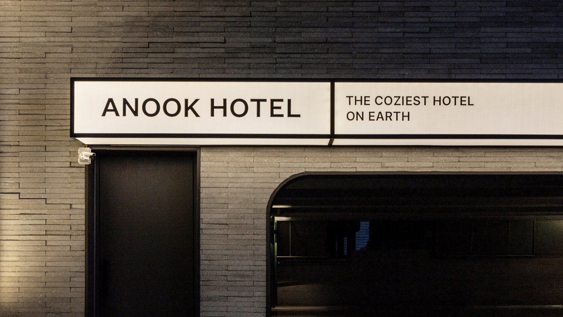 A sign for Anook Hotel stating 'THE COZIEST HOTEL ON EARTH.'