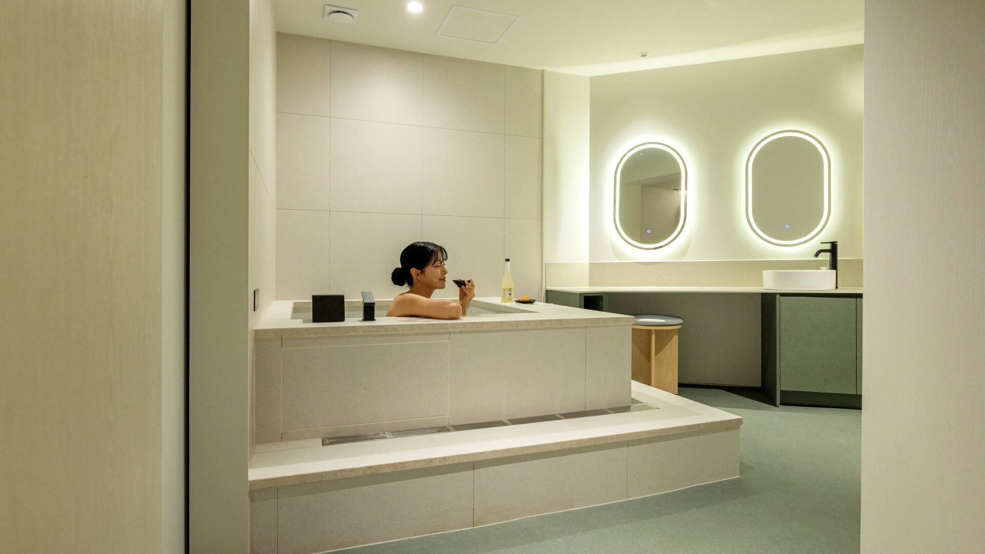 Un baño moderno con una bañera independiente, un tocador con espejo y un inodoro.