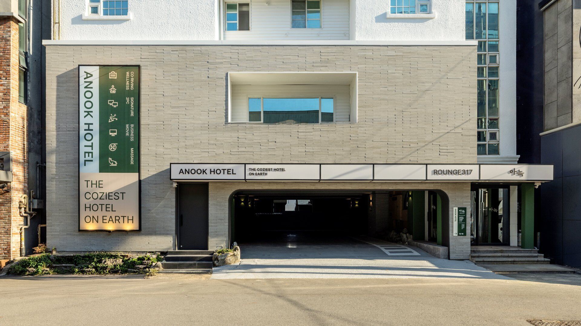 A hotel entrance with a sign for 'Anook Hotel' and 'The Coziest Hotel on Earth.'